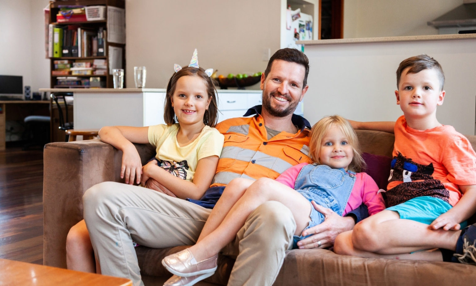 happy father with his children sitting on the sofa