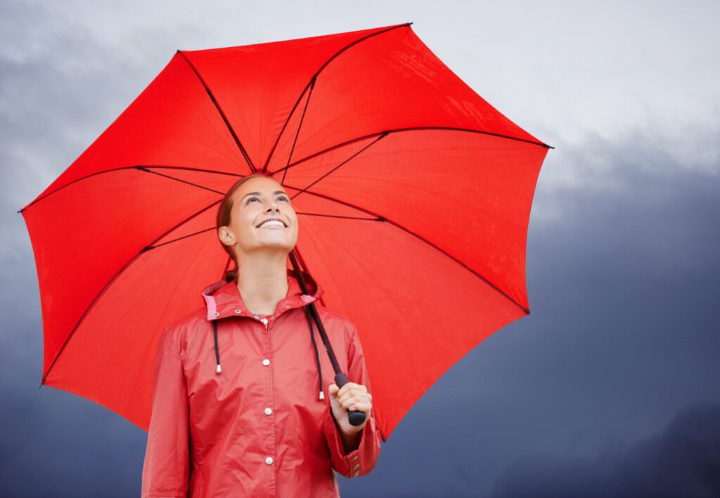 Woman protected from rain by an umbrella