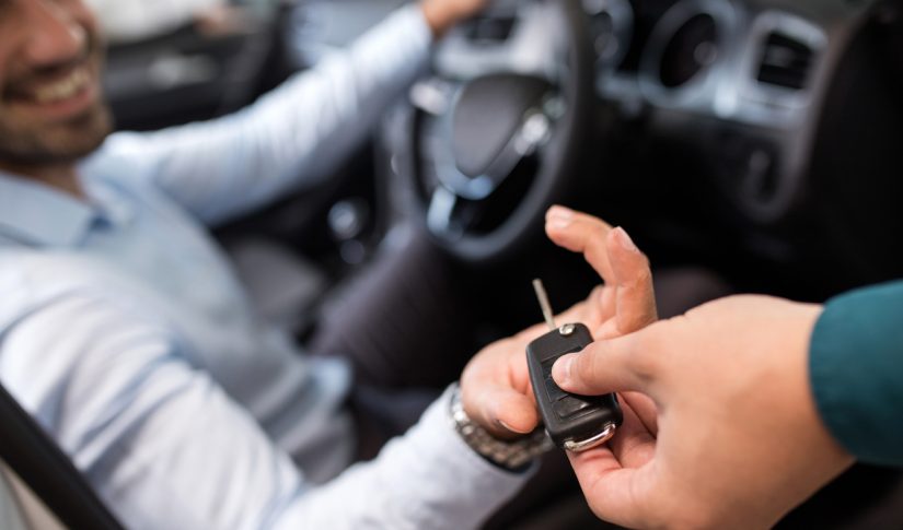 close up of a man receiving new car key Car Rental