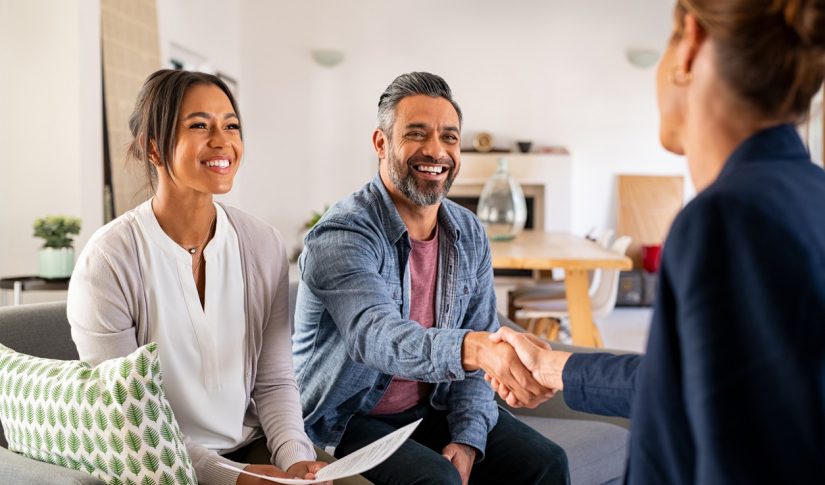 Multiethnic couple handshake with consultant at home Settling In