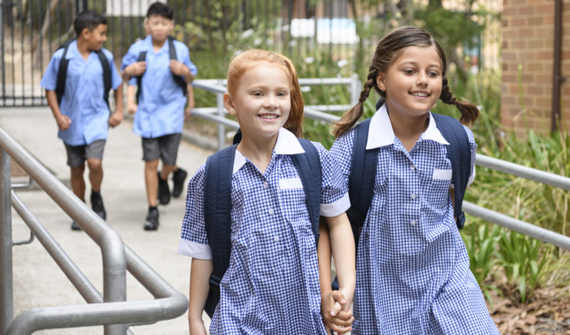 Two school girls holding hands on way to school Home & School Search
