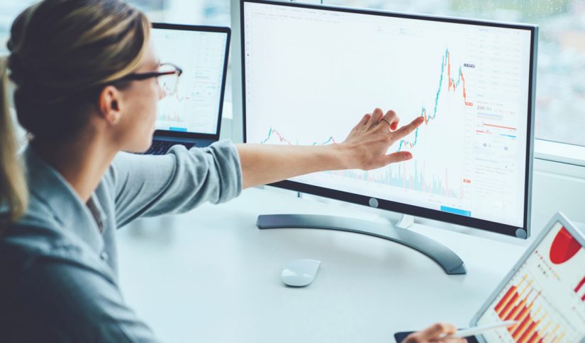 Business woman study financial market to calculate possible risks and profits.Female economist accounting money with statistics graphs pointing on screen of computer at desktop. Quotations on exchange Finance