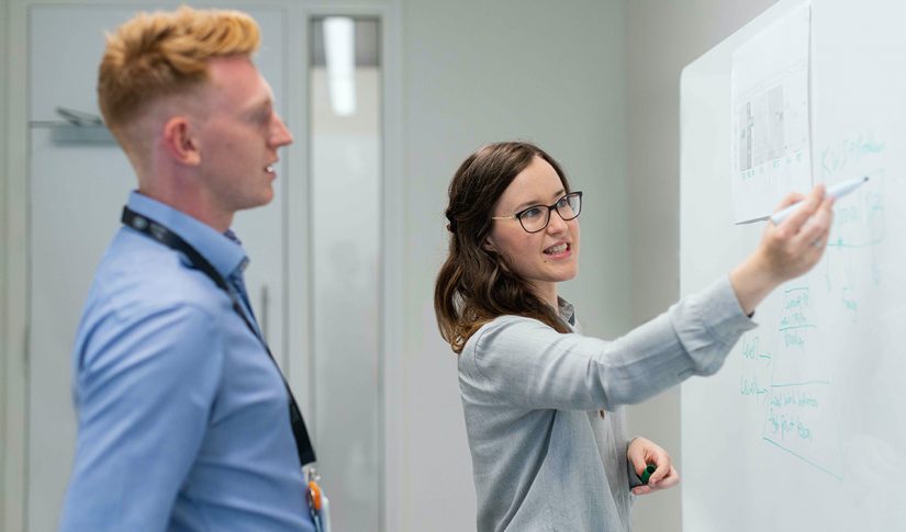young professionals in discussion at whiteboard in the office Manufacturing