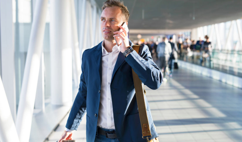 Man talking on phone in airport Travel Management
