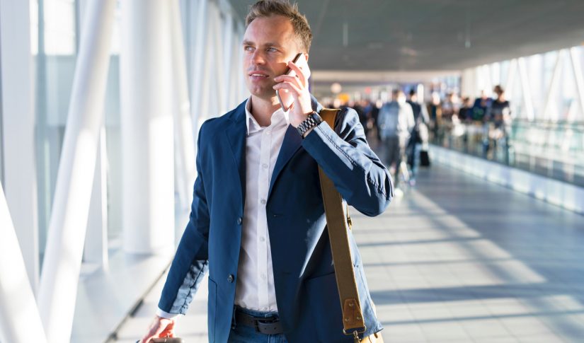 man talking on phone in airport Travel Management